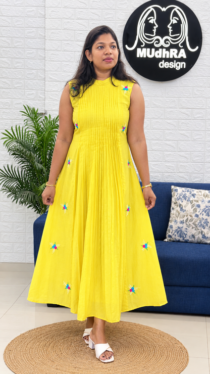 Butter yellow sleeveless Chanderi frock with central pleats and scattered handwork motifs, full-length view